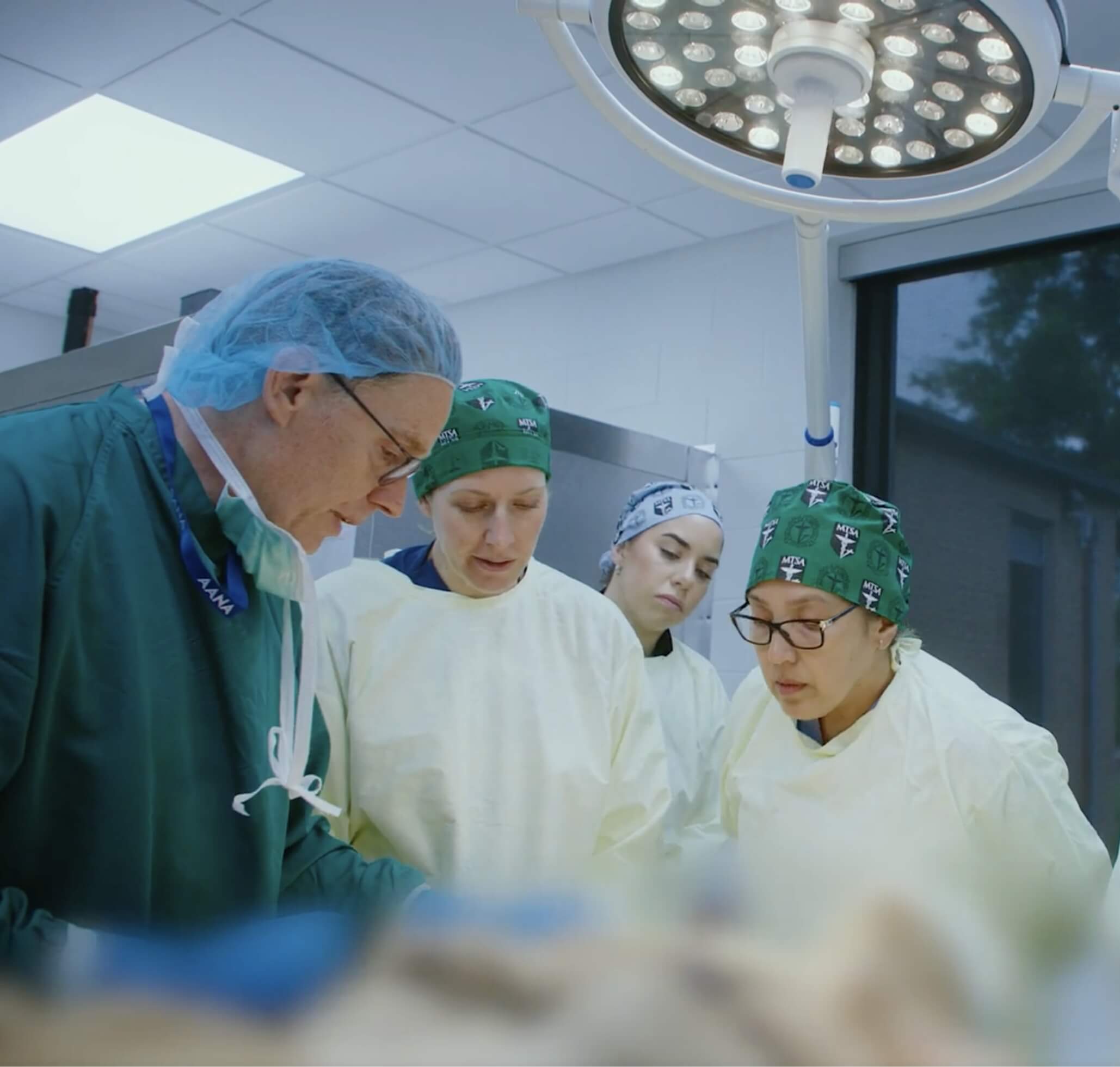 Professor teaching skill in operating room to 3 CRNA students