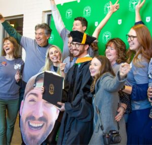 Graduate smiling excitedly with his family