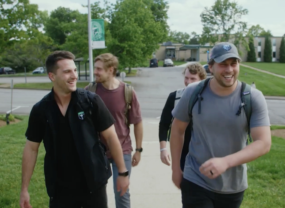 Male CRNA students walking outside laughing