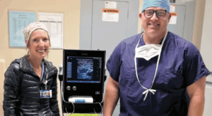 Two CRNA's smiling next to an ultrasound machine