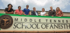 Students standing in front of the MTSA school sign